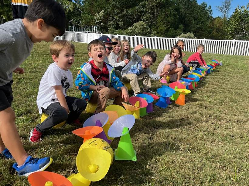 Kids mid-celebration around a pile of colorful cones